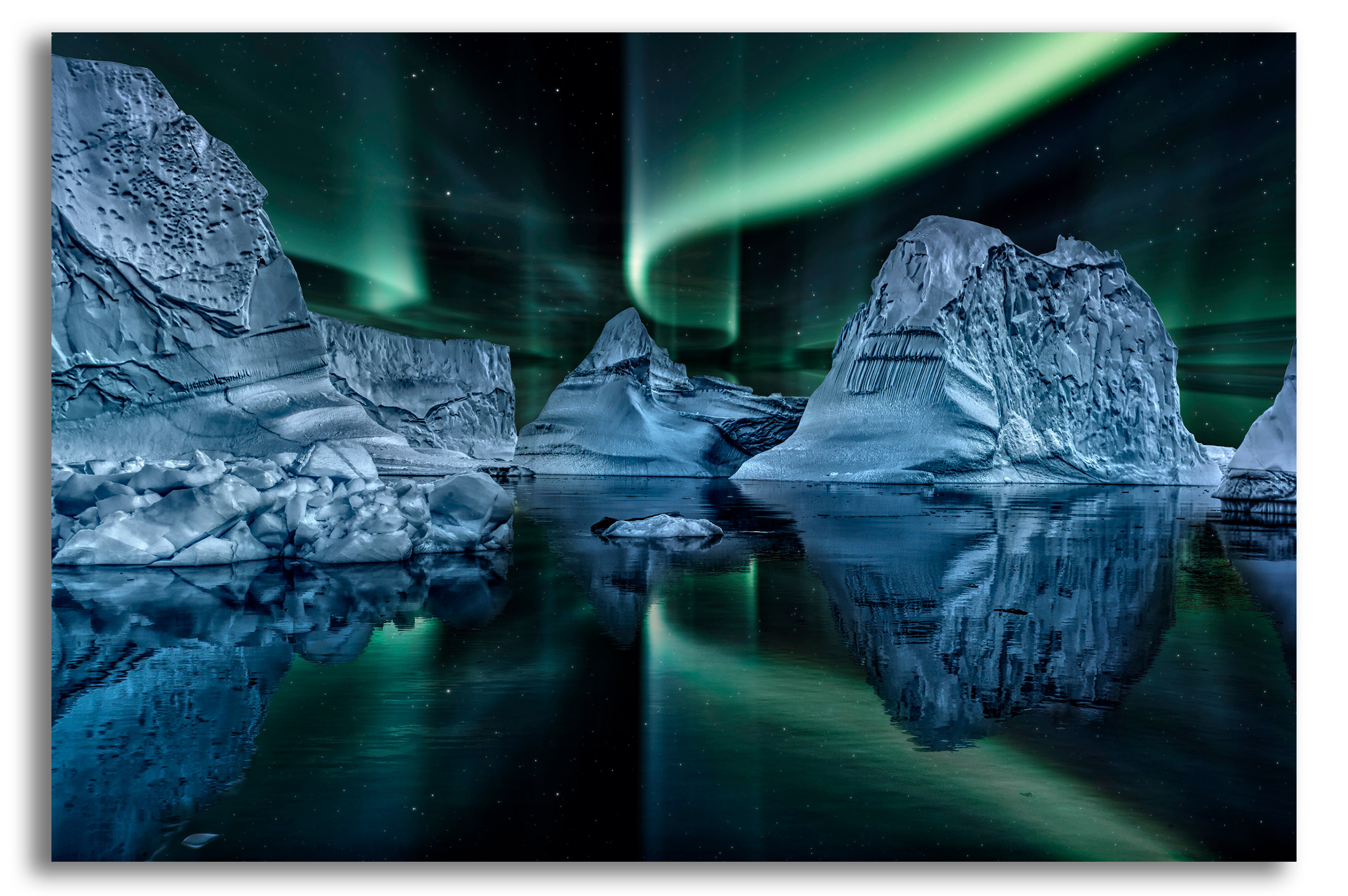 Iceberg floating in greenland fjord at night with green northern lights stock photo
