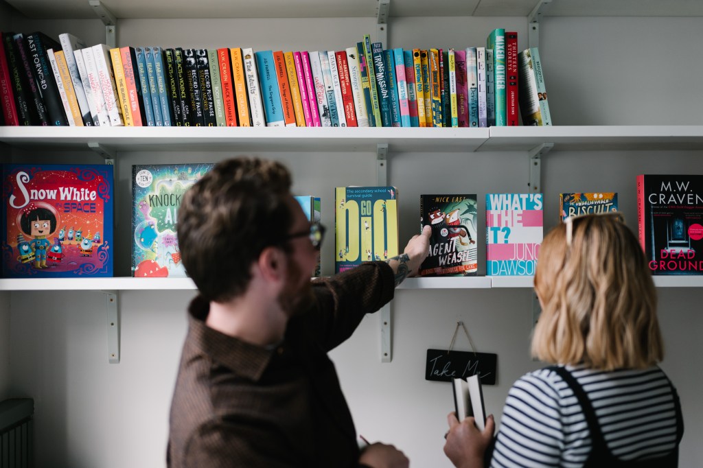 time warner books uk Colleagues browsing a bookshelf.